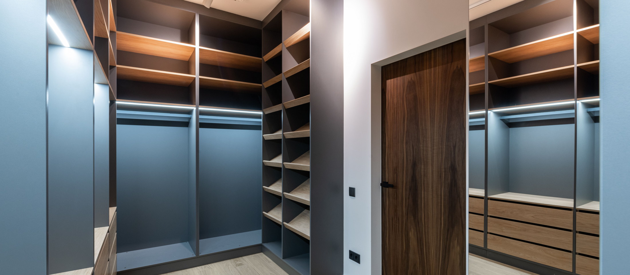 Vestidor a medida con módulos en gris grafito, baldas de madera y puerta de nogal